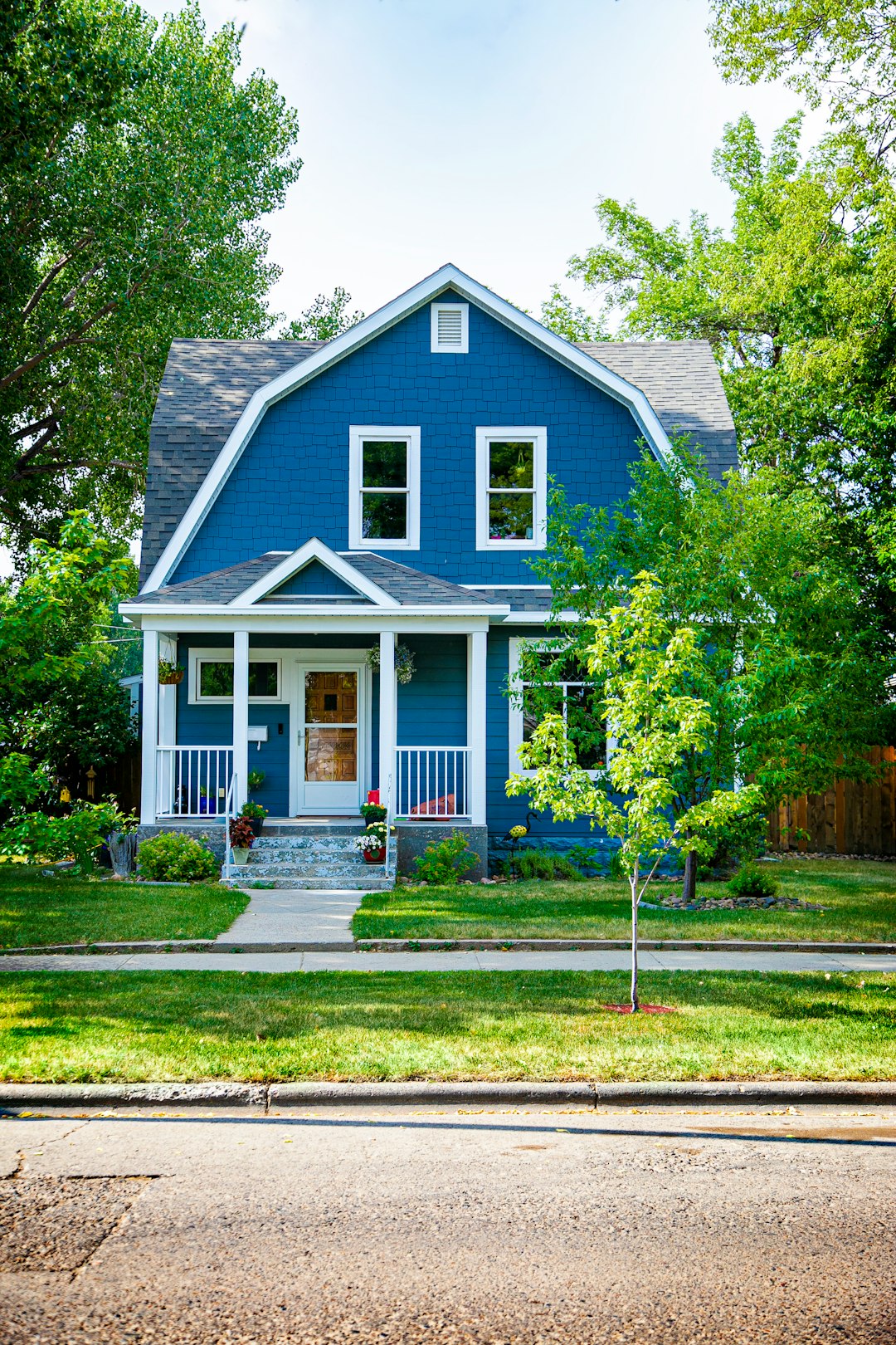 blue-and-white-wooden-house-near-green-trees-during-daytime-pmqtjdvbkdm