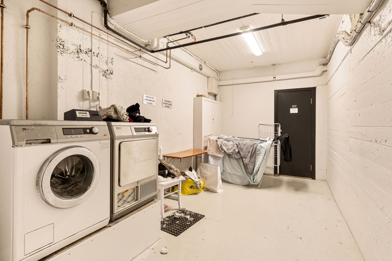Services Spacious laundry room featuring washing machine and dryer with visible piping.